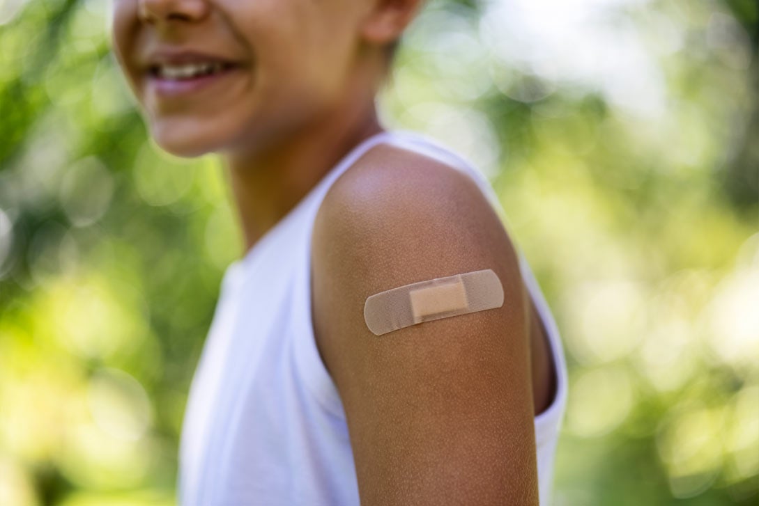 Child's arm with band aid from vaccine