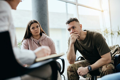 Stressed man listening in group therapy session