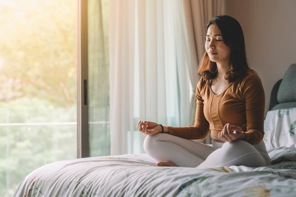 Young woman meditating at home