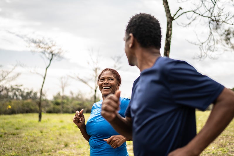 Woman in blue shirt facing her running partner and smiling