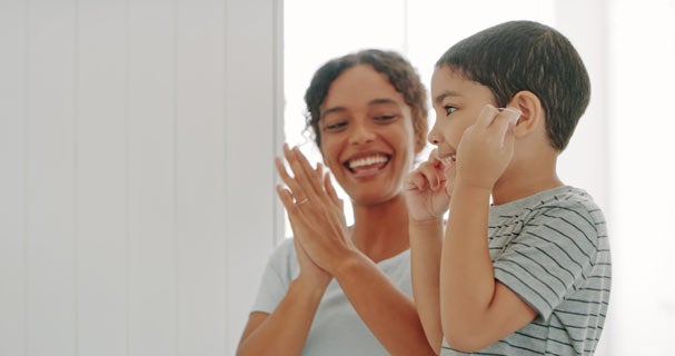 Mother watching son flossing his teeth