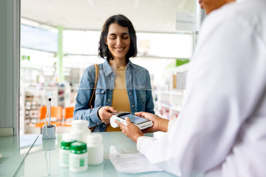 Woman paying by card while buying medicines at the pharmacy