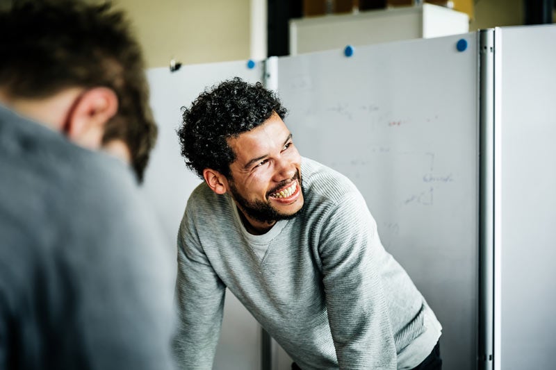 Young man laughing with a colleague