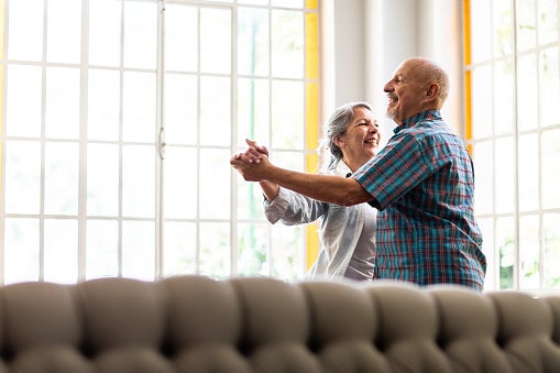 Older couple dancing in their living room