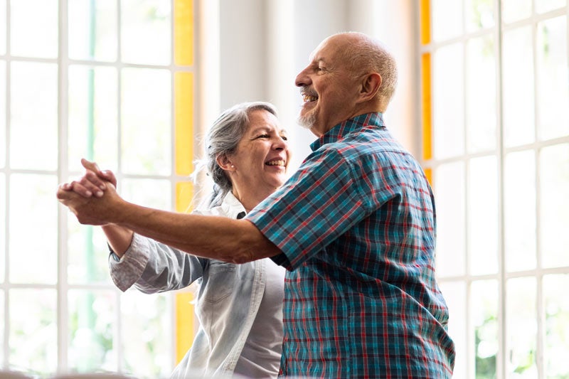 Senior couple dancing at home