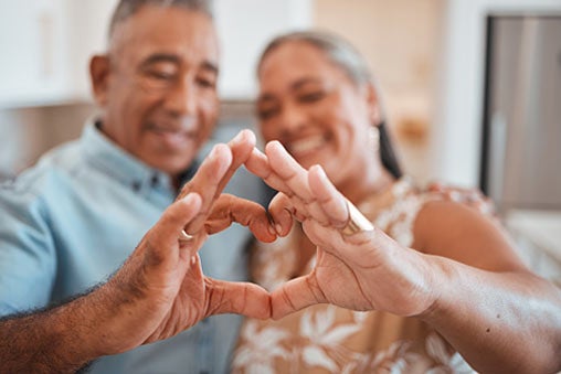 Mature couple making a heart with their hands