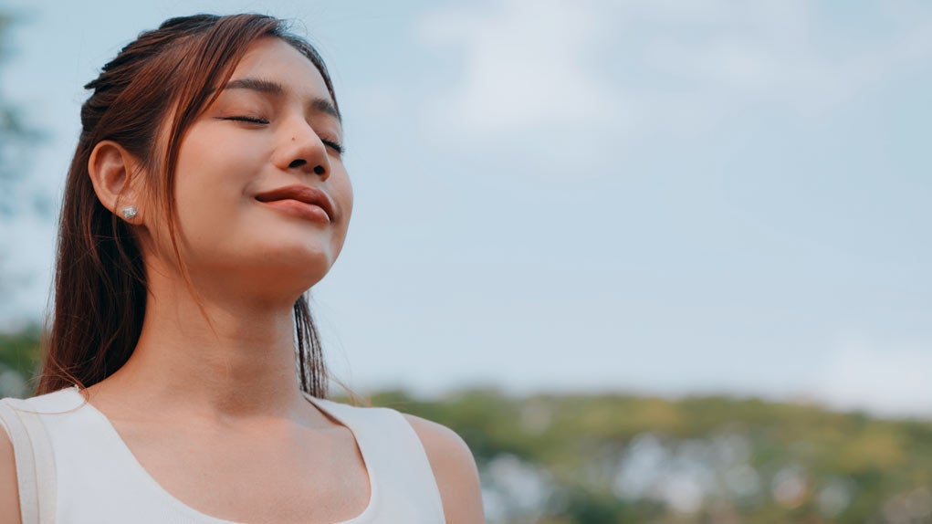 A woman closes her eyes in a peaceful moment